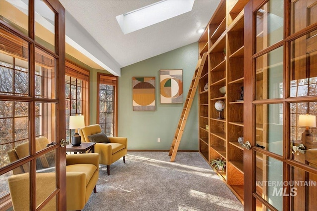 sitting room with carpet, lofted ceiling with skylight, a textured ceiling, and french doors