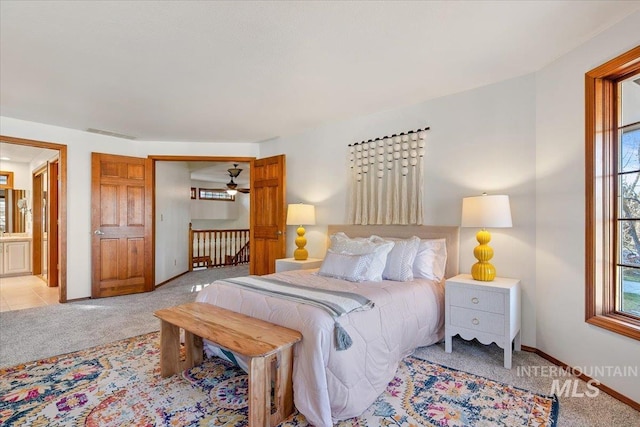 carpeted bedroom featuring ensuite bath