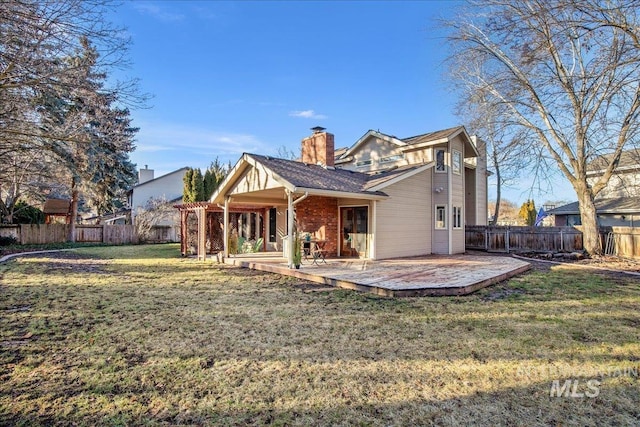 back of house with a yard and a patio