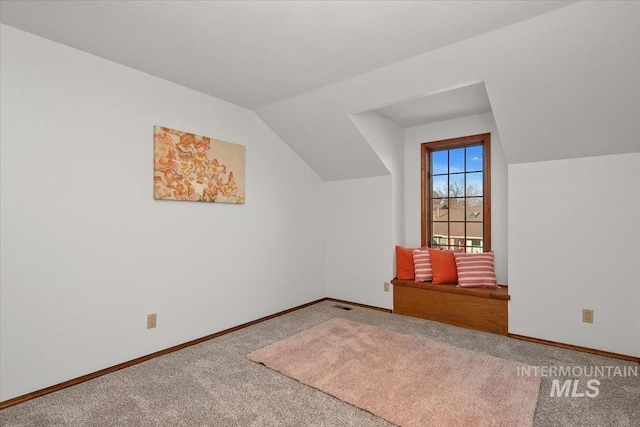 additional living space featuring carpet flooring and vaulted ceiling