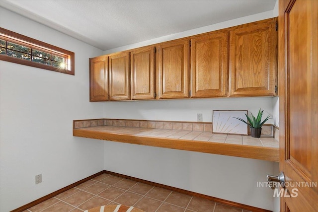 unfurnished office featuring light tile patterned flooring