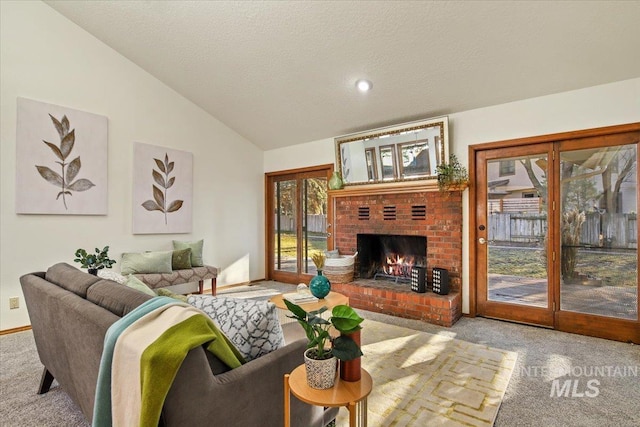 living room with lofted ceiling, light carpet, a textured ceiling, and a brick fireplace