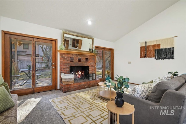 living room featuring carpet flooring, plenty of natural light, lofted ceiling, and a fireplace