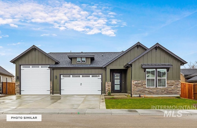 view of front of home with board and batten siding, concrete driveway, fence, and stone siding