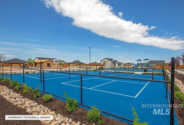 view of sport court featuring fence and a residential view