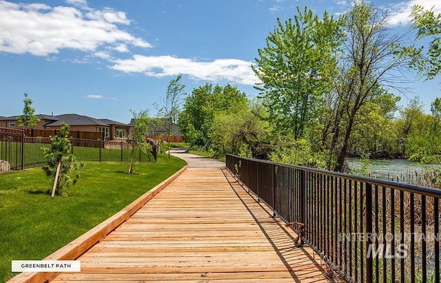 view of home's community with a yard and fence