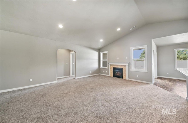 3225 N Quarrystone Way, Meridian, ID 83646 - unfurnished living room with carpet floors, arched walkways, baseboards, lofted ceiling, and recessed lighting
