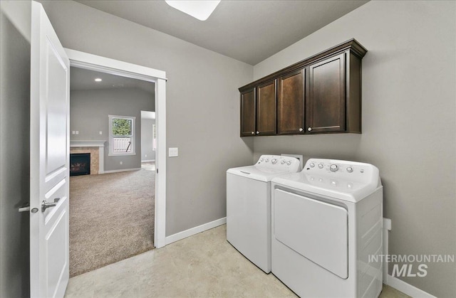 3225 N Quarrystone Way, Meridian, ID 83646 - laundry room with washing machine and clothes dryer, cabinet space, a premium fireplace, baseboards, and light carpet