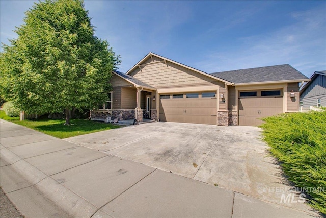 3225 N Quarrystone Way, Meridian, ID 83646 - craftsman house featuring stone siding, an attached garage, driveway, and a front yard