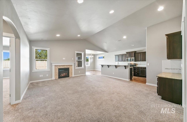3225 N Quarrystone Way, Meridian, ID 83646 - unfurnished living room with light colored carpet, baseboards, vaulted ceiling, a fireplace, and recessed lighting
