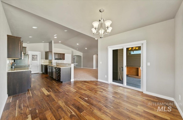 3225 N Quarrystone Way, Meridian, ID 83646 - kitchen with open floor plan, light countertops, dark brown cabinetry, a chandelier, and vaulted ceiling