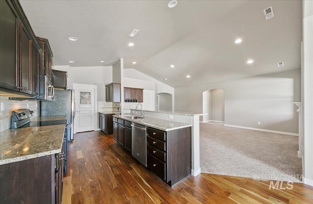 3225 N Quarrystone Way, Meridian, ID 83646 - kitchen with appliances with stainless steel finishes, a sink, arched walkways, dark brown cabinetry, and lofted ceiling