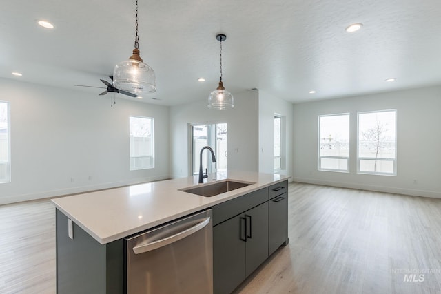 kitchen featuring a sink, pendant lighting, open floor plan, and stainless steel dishwasher