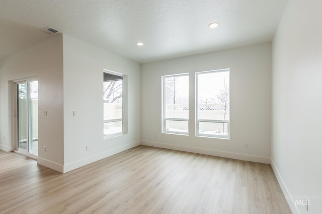 unfurnished room featuring recessed lighting, visible vents, light wood-style flooring, and baseboards