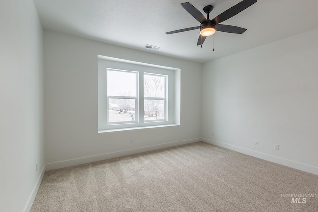 spare room featuring baseboards, visible vents, ceiling fan, and carpet flooring