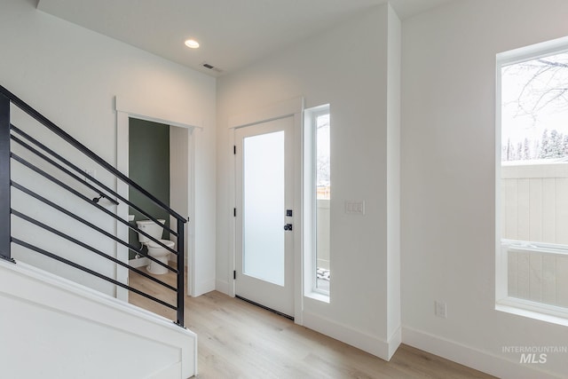 foyer entrance featuring light wood-style floors, recessed lighting, baseboards, and stairs