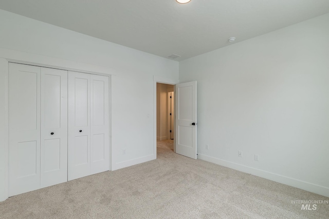 unfurnished bedroom featuring a closet, carpet flooring, visible vents, and baseboards