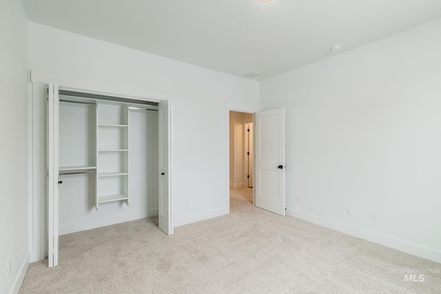 unfurnished bedroom with carpet, baseboards, and a closet