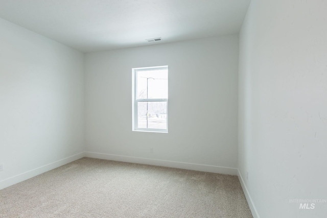 empty room with visible vents, baseboards, and light colored carpet