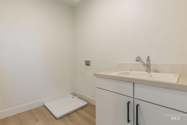 bathroom with wood finished floors, vanity, and baseboards