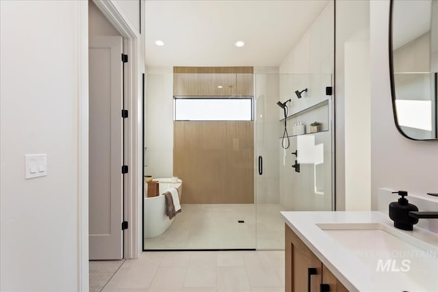 bathroom featuring tile patterned flooring, walk in shower, and vanity