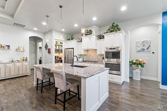 2133 N Star Garnet Ave, Kuna, ID 83634 - kitchen with appliances with stainless steel finishes, a sink, dark wood finished floors, backsplash, and a kitchen island with sink