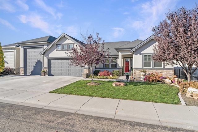 2133 N Star Garnet Ave, Kuna, ID 83634 - view of front of house with concrete driveway, stucco siding, stone siding, a front lawn, and an attached garage