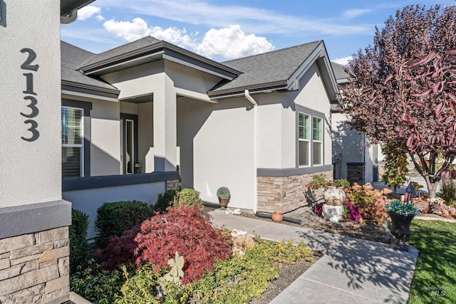 2133 N Star Garnet Ave, Kuna, ID 83634 - view of exterior entry with stone siding, stucco siding, and a shingled roof