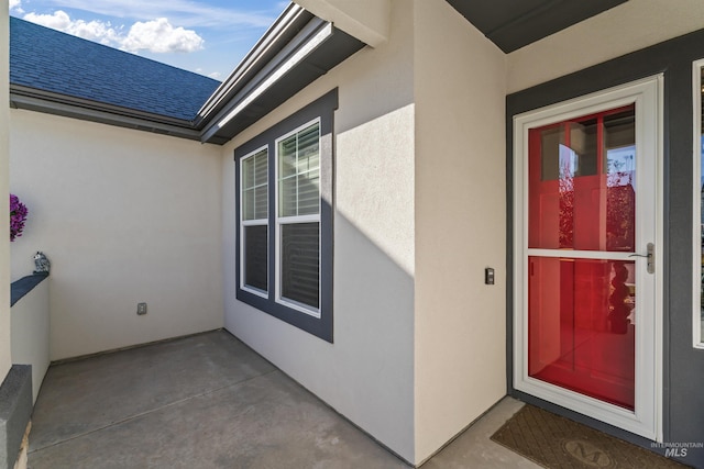 2133 N Star Garnet Ave, Kuna, ID 83634 - view of exterior entry featuring stucco siding and a shingled roof