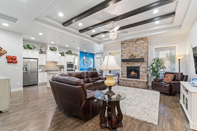 2133 N Star Garnet Ave, Kuna, ID 83634 - living room with a raised ceiling, ceiling fan, a stone fireplace, dark wood-style flooring, and recessed lighting