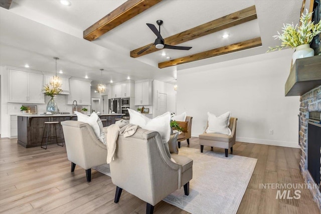 1279 W Ultar, Nampa, ID 83686 - living area featuring ceiling fan, a fireplace, beamed ceiling, recessed lighting, and light wood-style flooring
