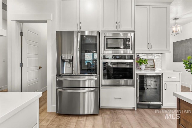 1279 W Ultar, Nampa, ID 83686 - kitchen with beverage cooler, light countertops, light wood-style floors, and appliances with stainless steel finishes