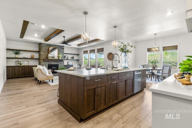 1279 W Ultar, Nampa, ID 83686 - kitchen with stainless steel dishwasher, dark brown cabinets, a stone fireplace, light countertops, and a sink