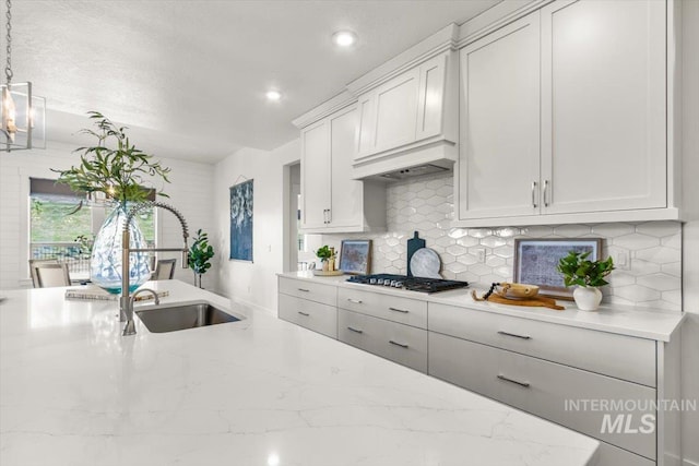 1279 W Ultar, Nampa, ID 83686 - kitchen with decorative backsplash, gas stovetop, light stone counters, recessed lighting, and white cabinetry
