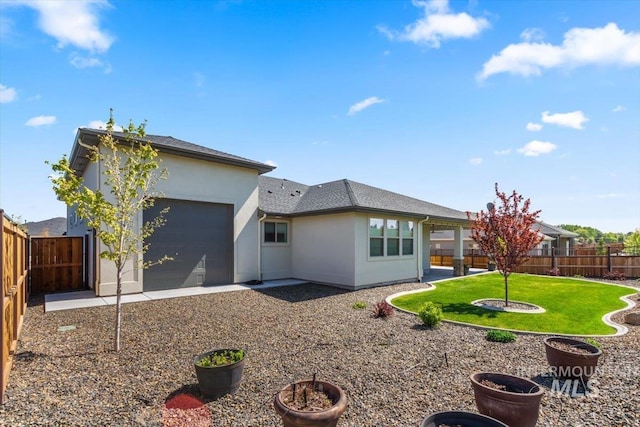 1279 W Ultar, Nampa, ID 83686 - back of property featuring stucco siding, a lawn, a fenced backyard, and a garage