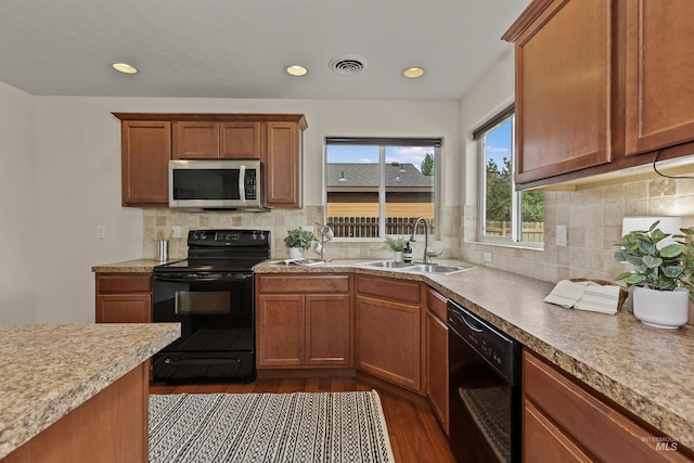 11422 W Darkwood St, Star, ID 83669 - kitchen with black appliances, a sink, dark wood finished floors, light countertops, and tasteful backsplash