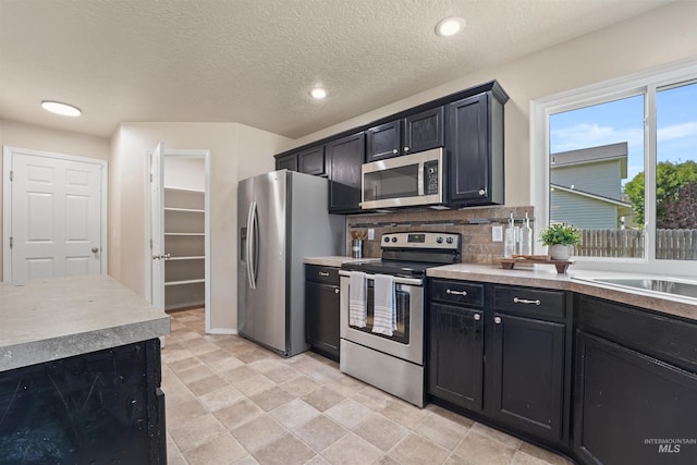 5217 Weston Ave, Caldwell, ID 83607 - kitchen featuring appliances with stainless steel finishes, dark cabinetry, tasteful backsplash, light countertops, and recessed lighting