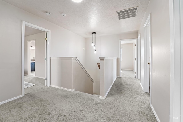 5217 Weston Ave, Caldwell, ID 83607 - hall with an upstairs landing, carpet floors, and a textured ceiling