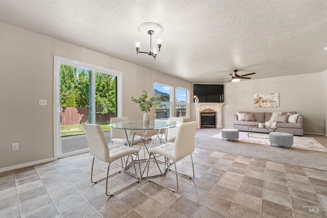 5217 Weston Ave, Caldwell, ID 83607 - dining area with a ceiling fan, a glass covered fireplace, a textured ceiling, and a chandelier