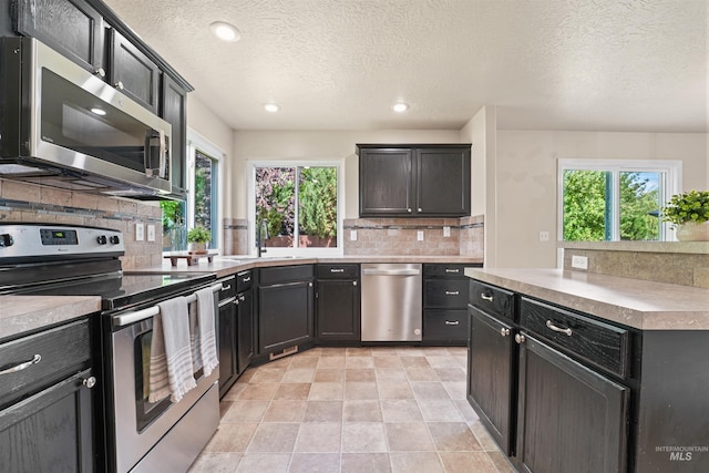 5217 Weston Ave, Caldwell, ID 83607 - kitchen featuring appliances with stainless steel finishes, tasteful backsplash, a textured ceiling, recessed lighting, and light countertops