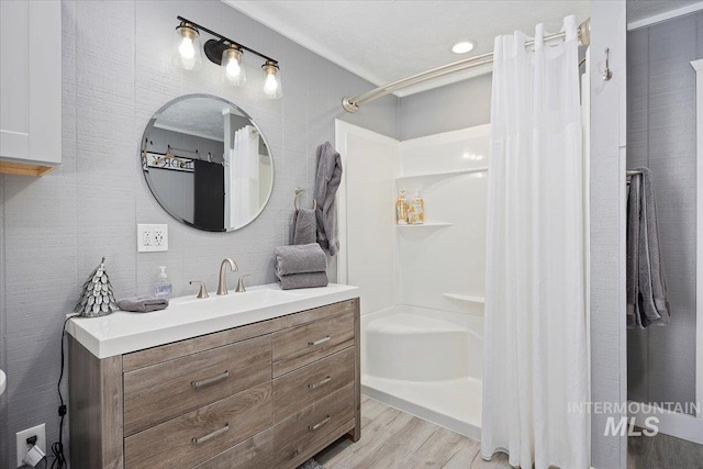 bathroom with vanity, curtained shower, and wood-type flooring