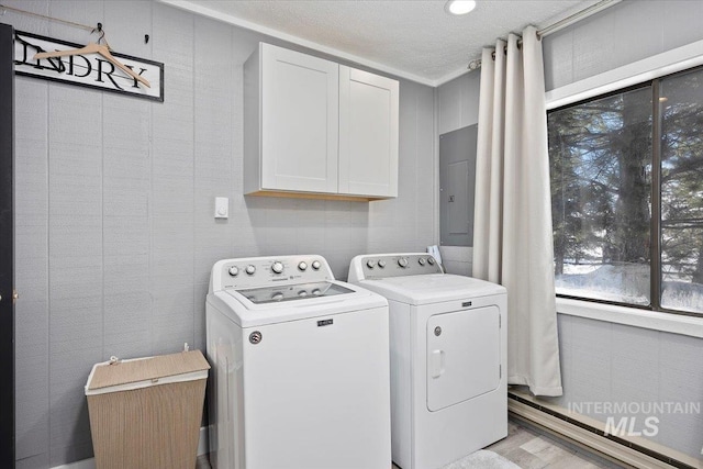 laundry room with cabinets, electric panel, washer and dryer, and a textured ceiling