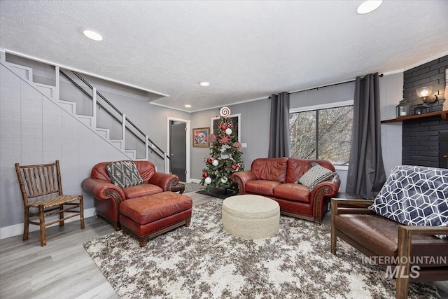 living room with light hardwood / wood-style floors and a textured ceiling