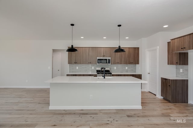 8172 E Red Horse St, Nampa, ID 83687 - kitchen featuring stainless steel microwave, modern cabinets, light countertops, backsplash, and recessed lighting