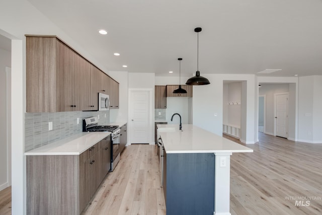8172 E Red Horse St, Nampa, ID 83687 - kitchen featuring appliances with stainless steel finishes, light wood finished floors, tasteful backsplash, modern cabinets, and light countertops