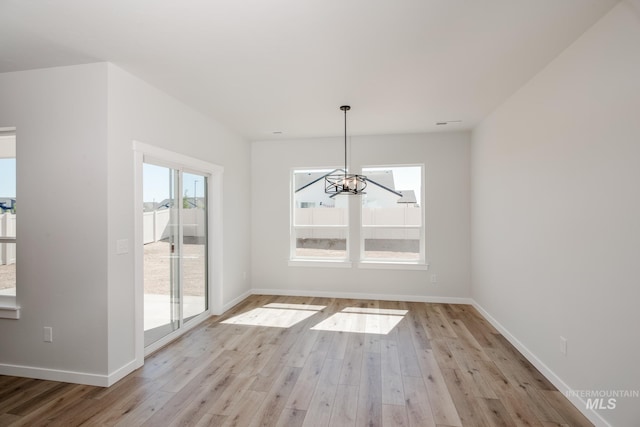8172 E Red Horse St, Nampa, ID 83687 - unfurnished dining area featuring a chandelier, light wood-type flooring, and baseboards