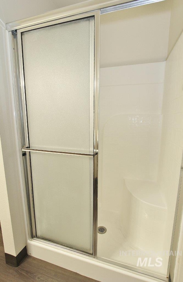 1300 Diamond Ct, Nampa, ID 83686 - bathroom featuring a stall shower, wood finished floors, and baseboards