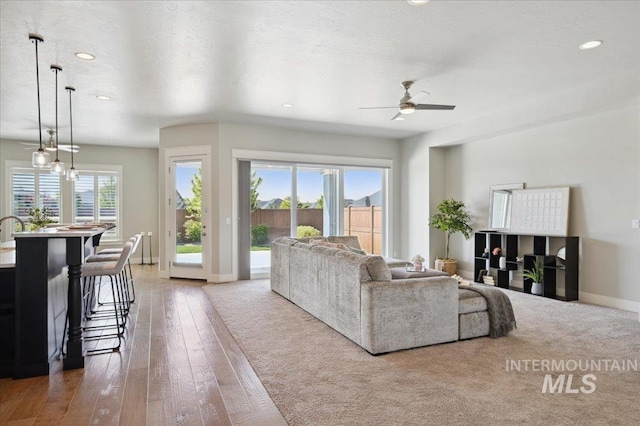living room with a ceiling fan, baseboards, recessed lighting, and hardwood / wood-style flooring