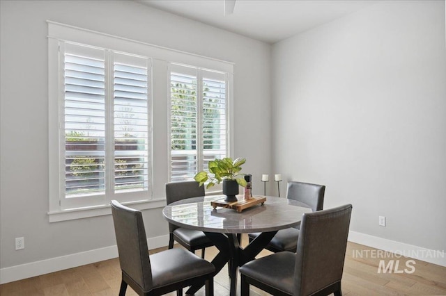 dining area featuring baseboards and light wood-style floors
