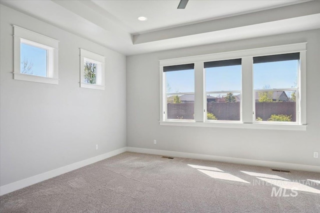 carpeted empty room with baseboards, visible vents, and recessed lighting